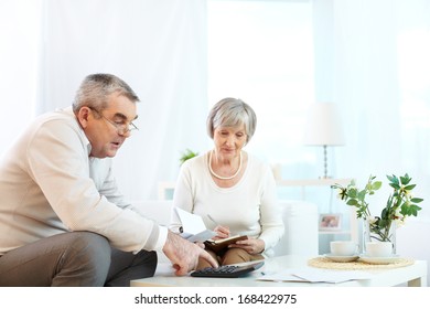 Portrait Of Mature Man And His Wife Making Financial Revision At Home