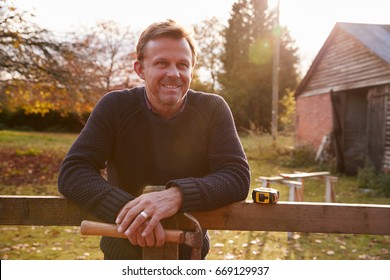 Portrait Of Mature Man Repairing Garden Fence