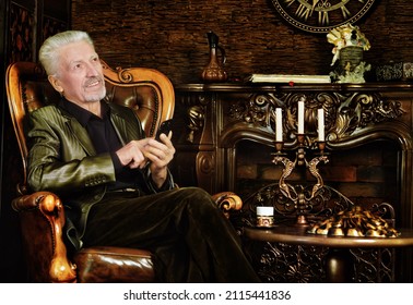 Portrait Of A Mature Man Sitting On A Chair With Smartphone