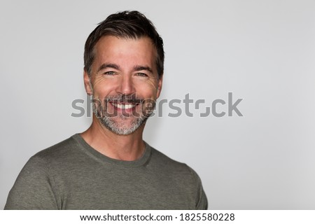 Portrait Of A Mature Man Smiling At The Camera. Isolated on white. Left side.

