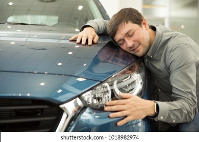 Portrait Of A Mature Man Smiling Joyfully Embracing A New Car At The Dealership Showroom Copyspace Love Driving Masculine Hobby Transport Technology Modern Vehicle Buying Sales Consumerism Shopping.