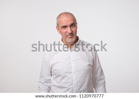 Portrait of mature sad man in white shirt. He had bad mood. Concept of negative emotion, facial expression