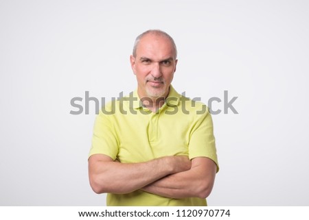 Portrait of mature sad man in yellow t-shirt. He had bad mood. Concept of negative emotion, facial expression