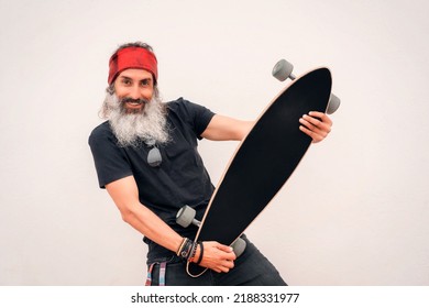 Portrait Mature Or Senior Latin Man Posing With A Skateboard In His Hands Smiling And Happy