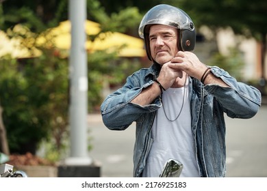 Portrait Of Mature Senior Man Taking Off Helmet After Riding Motorcycle