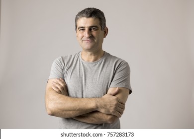 Portrait Of Mature White Man 40 To 50 Years Old Smiling Happy Showing Nice And Positive Face Expression With Folded Crossed Arms Isolated On Grey Background In Feelings And Emotions Concept