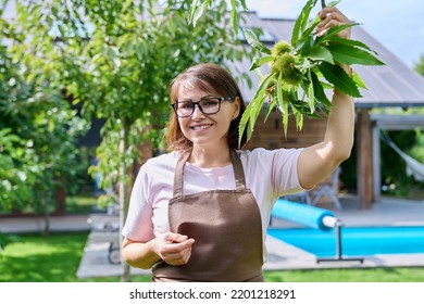 Portrait Of Mature Woman In Apron In Backyard Garden