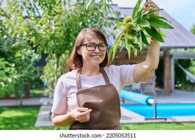 Portrait Of Mature Woman In Apron In Backyard Garden