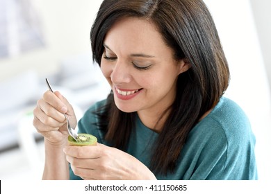 Portrait Of Mature Woman Eating Kiwi