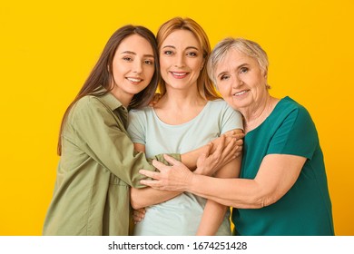 Portrait Of Mature Woman With Her Adult Daughter And Mother On Color Background