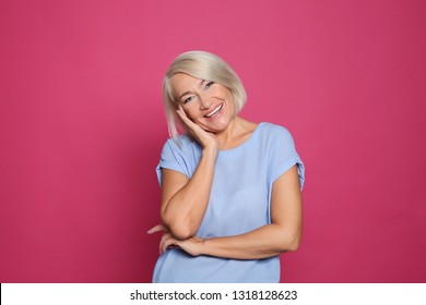 Portrait Of Mature Woman Laughing On Color Background