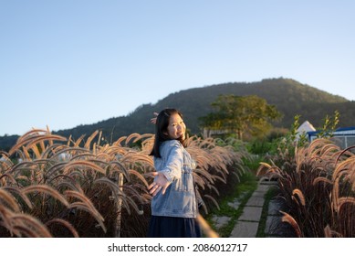 Portrait Of Mature Woman Looking At Flowers In Meadow Field