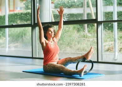 Portrait of mature woman practicing pilates exercises with fitness ring - Powered by Shutterstock