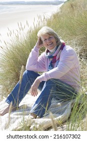 Portrait Of Mature Woman Sitting On Beach