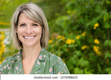 Portrait Of A Mature Woman Smiling At The Camera. She Is Really Happy In At The Park