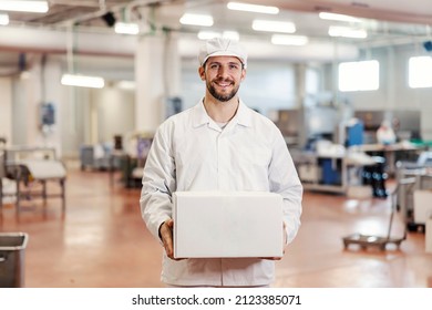 Portrait of a meat factory worker holding box with fresh meat and smiling at the camera. - Powered by Shutterstock