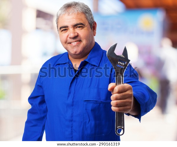 portrait of a
mechanic holding a monkey
wrench
