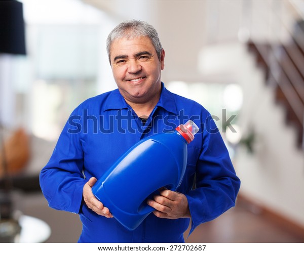portrait of a\
mechanic holding an oil\
bottle
