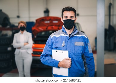 Portrait of mechanic with protective face mask working in car repair service. - Powered by Shutterstock