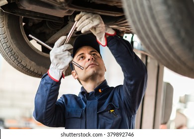 Portrait Of A Mechanic Repairing A Lifted Car