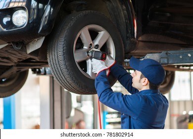 Portrait of a mechanic replacing a wheel - Shutterstock ID 781802914
