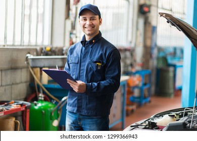 Portrait of a mechanic at work in his garage - Shutterstock ID 1299366943