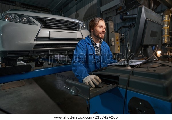 Portrait of mechanic working at computer in\
service center