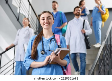 Portrait of medical student with books on staircase in college, space for text - Powered by Shutterstock