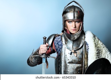 Portrait Of A Medieval Female Knight In Armour Over Grey Background.