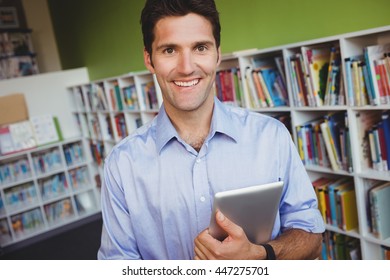 Porträt eines Mannes, der ein Buch in einer Bibliothek hält