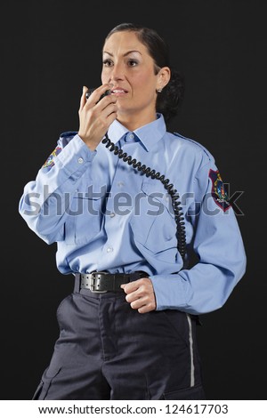 Portrait of a mid-aged policewoman talking on her CB radio