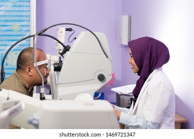 Portrait Of Middle Age Asian Man Having Eye Examinating Check With Digital Optometry Tools With Hijab Female Ophthamologists On Clinic Room -image