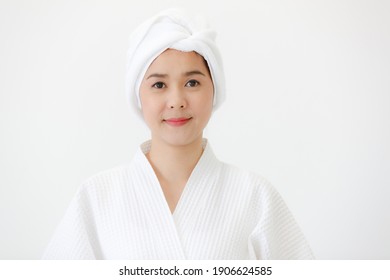 Portrait of middle age Asian woman with towel-covered around her head in the spa. She is smiling and looking at camera. Idea for female who care for health and skin.