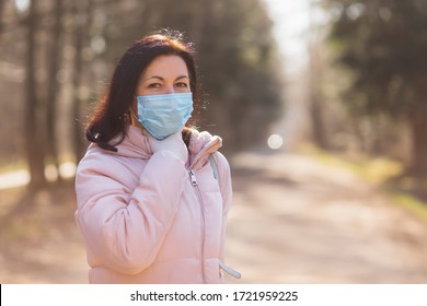 Portrait Of Middle Age Woman Wearing Protective Face Mask For Medical Precautions During CoVid 19 Pandemic. Throat Pain