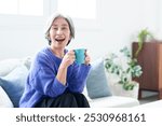 portrait of middle aged asian woman sitting on sofa in living room