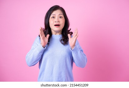 Portrait of middle aged Asian woman on pink background
 - Powered by Shutterstock