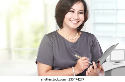 Portrait Of Middle Aged Business Woman Holding A Clipboard