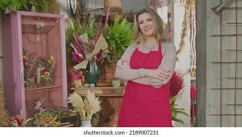 Portrait Of A Middle Aged Businesswoman Entrepreneur Owner Of Local Small Business Shop Wearing Apron Looking At Camera. Woman Owner Of Flower Shop Standing In Business Storefront