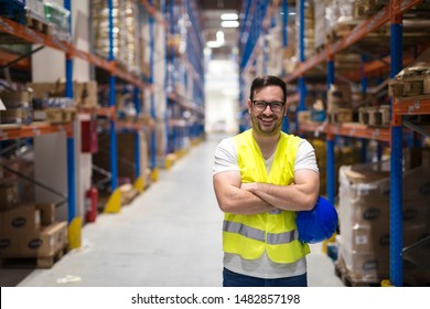 Portrait of middle aged caucasian warehouse worker standing in large warehouse distribution center with arms crossed. In background shelves with goods. Worker smilling and looking to the camera. - Shutterstock ID 1482857198