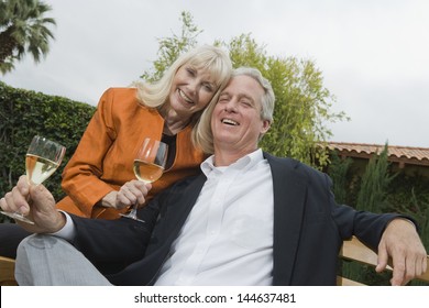 Portrait Of A Middle Aged Couple Drinking Wine In The Garden