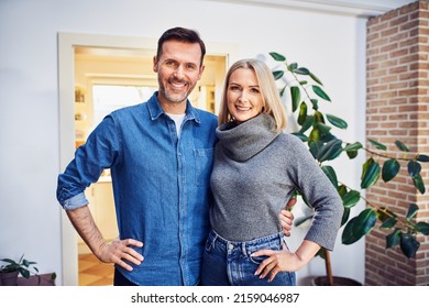 Portrait Of Middle Aged Couple Home Owners Stainding Indoors 