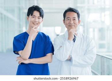 portrait of middle aged male asian doctor and young nurse in hospital - Powered by Shutterstock