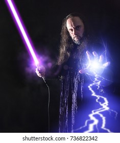 Portrait of a middle aged man posing on black background with laser sword light effects