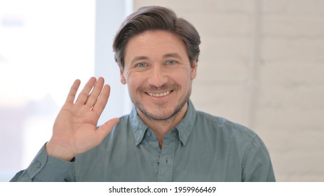 Portrait Of Middle Aged Man Waving, Welcoming