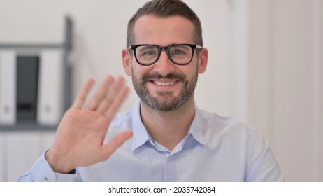 Portrait Of Middle Aged Man Waving At The Camera 