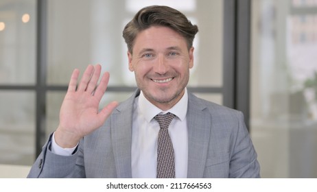 Portrait Of Middle Aged Man Waving, Welcoming