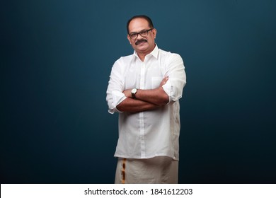 Portrait of a middle aged man wearing Kerala style traditional dress with folded hands