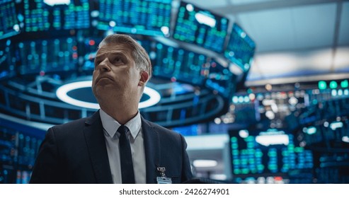 Portrait of a Middle Aged Man Working on the Floor in a Modern Stock Exchange Firm. Specialist Monitoring Companies and Funds, Securities, Derivatives, Investment Products, Bonds on Computer Displays