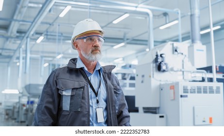 Portrait of a Middle Aged, Successful Male Engineer Putting On a White Hard Hat and Safety Glasses, While Walking at Electronics Manufacturing Factory. Heavy Industry Specialist Posing for Camera. - Powered by Shutterstock