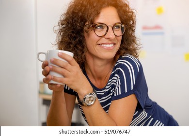 Portrait Of A Middle Aged Woman At The Office Drinking Coffee